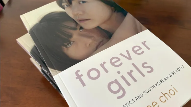 A few printed copies of Forever Girls by Professor Jinhee Choi on a desk
