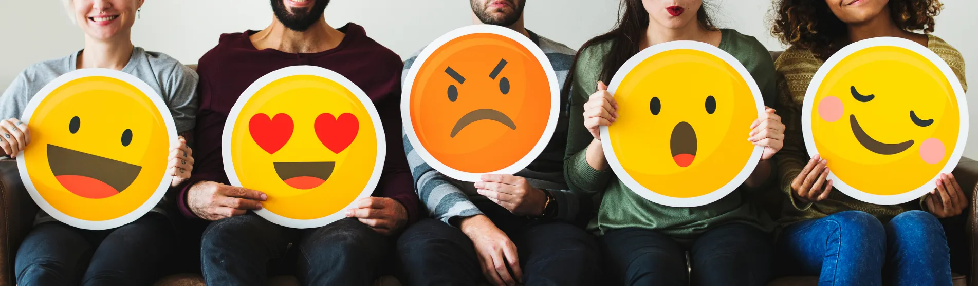 Group of diverse people holding emoticon icons (shutterstock)