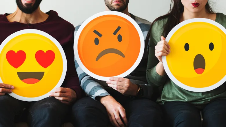 Group of diverse people holding emoticon icons (shutterstock)