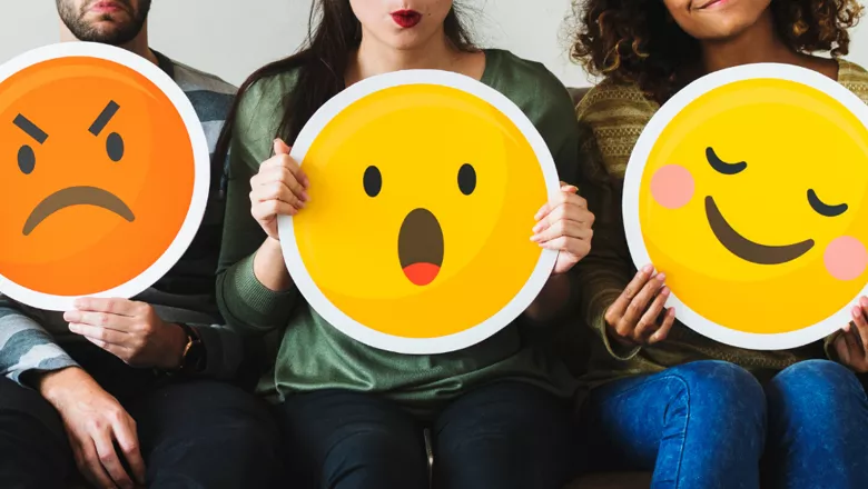 Group of diverse people holding emoticon icons (shutterstock)