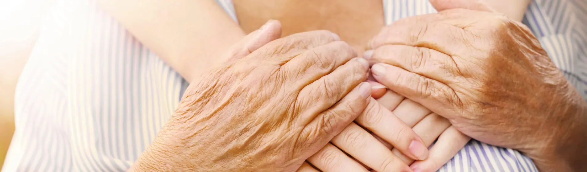 old and young hands hug, closeup (shutterstock)