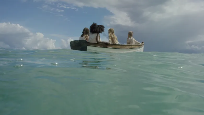 The image shows four people at sea in a boat.