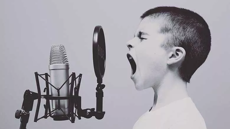Little boy screaming into a microphone