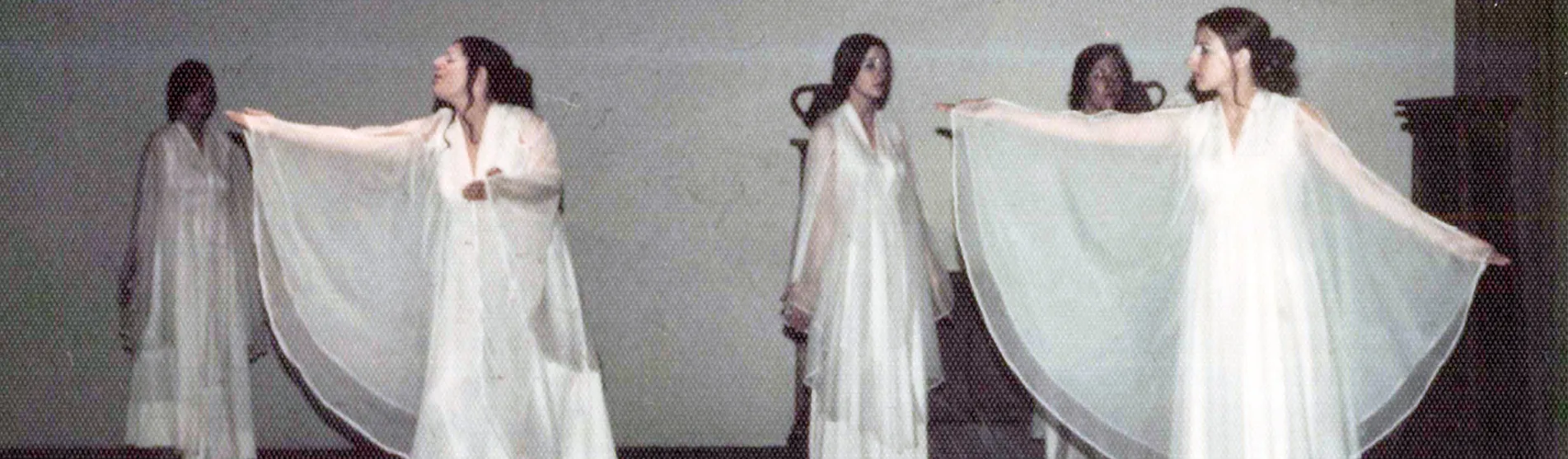 Mary in a white flowy dress as one of the Chorus members of the Greek play Medea.