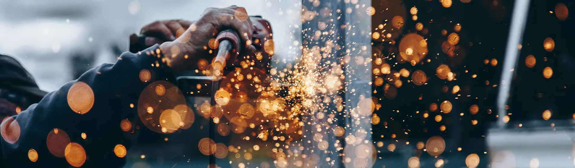 Sparks fly as a man uses a tool on a construction site.