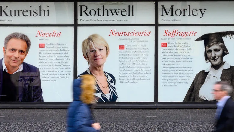 People walking past the notable alumni windows on the Strand.