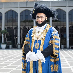 Hamza in profile dressed in his ceremonial outfit, of blue and gold