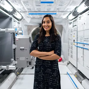 Vinita in profile, wearing a black dress marked like a chalkboard