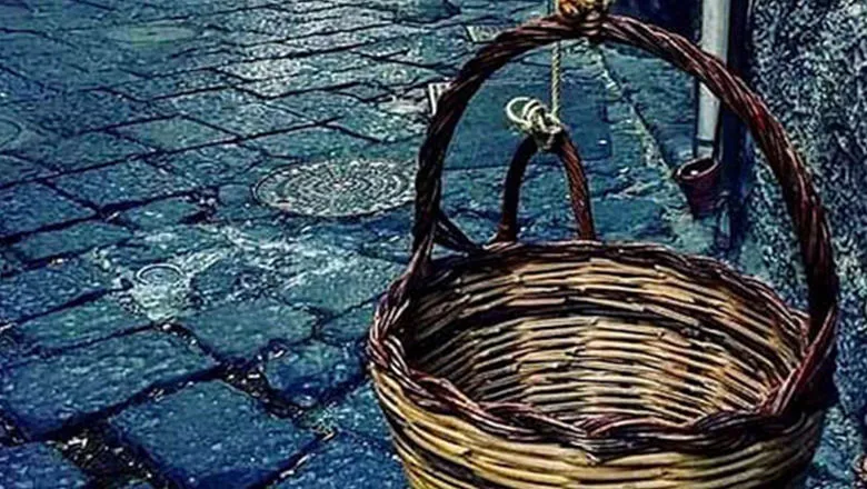 A picture of a wicker basket on a paved street.