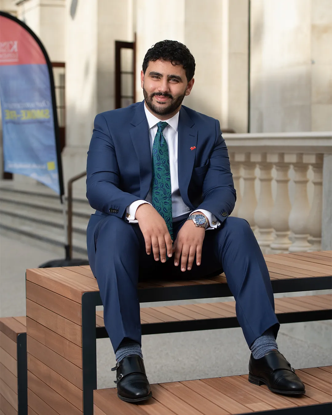 Mohamed Elhag sits on a bench with his shoes resting on the seat.