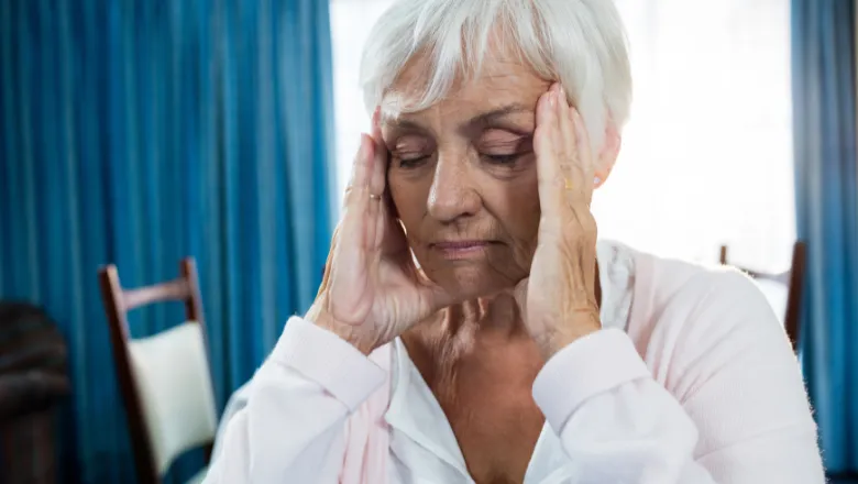 elderly lady holding head in pain csi 780x450