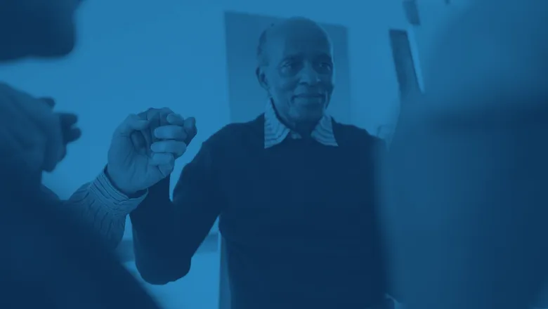 elderly man holding hands with group community support csi project 780x450