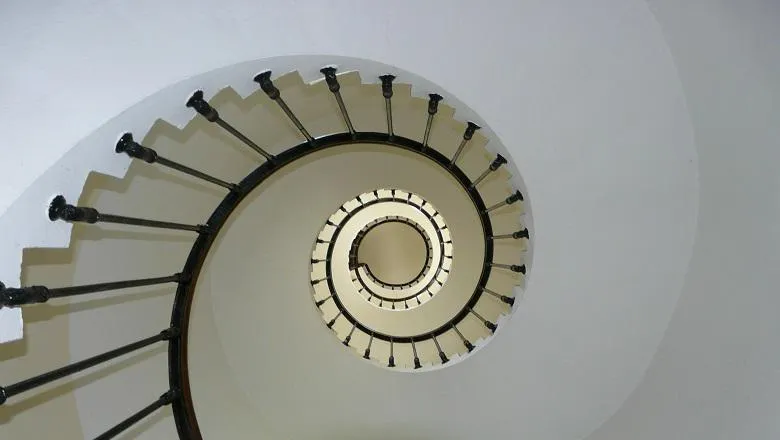 a white spiral staircase with black bannister