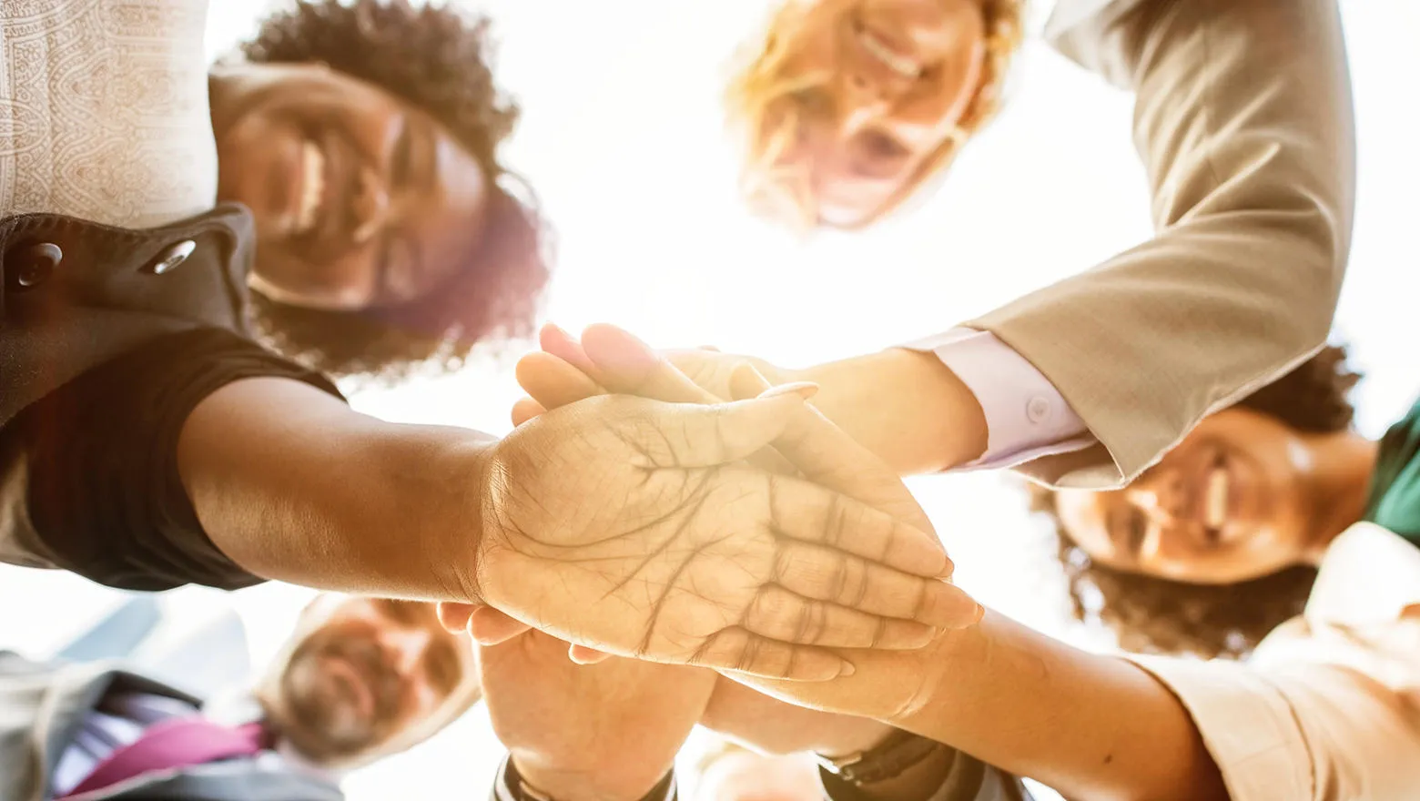 A diverse group holding hands in a circle, symbolising unity.