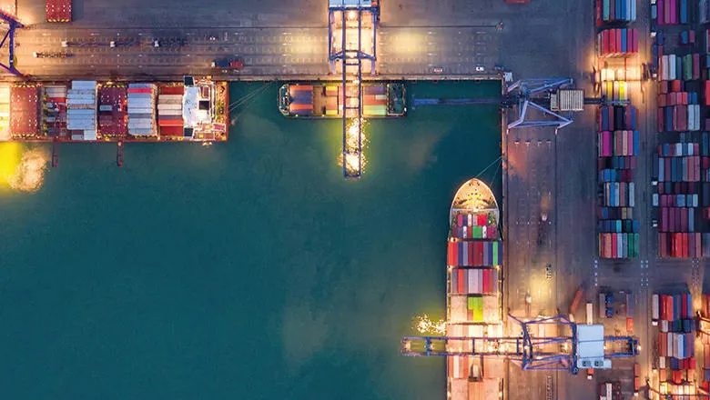 Aerial view of container ship and transportation in maritime port.