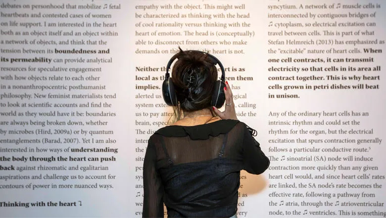 A person wearing headphones looking at a display of text
