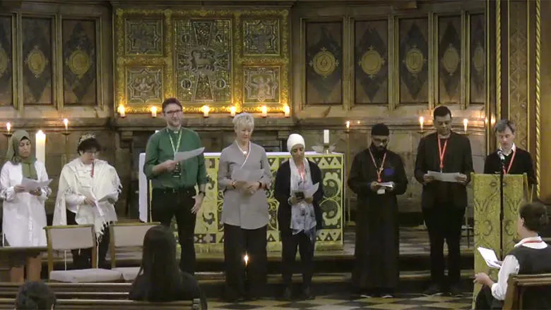 A group of people of different faiths standing in front on an alter