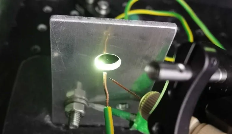 A diamond particle, visible as a tiny green dot is levitated at the centre of the experiment