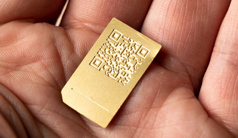 Prorotype of SIM card in colour gold being held within an open palm