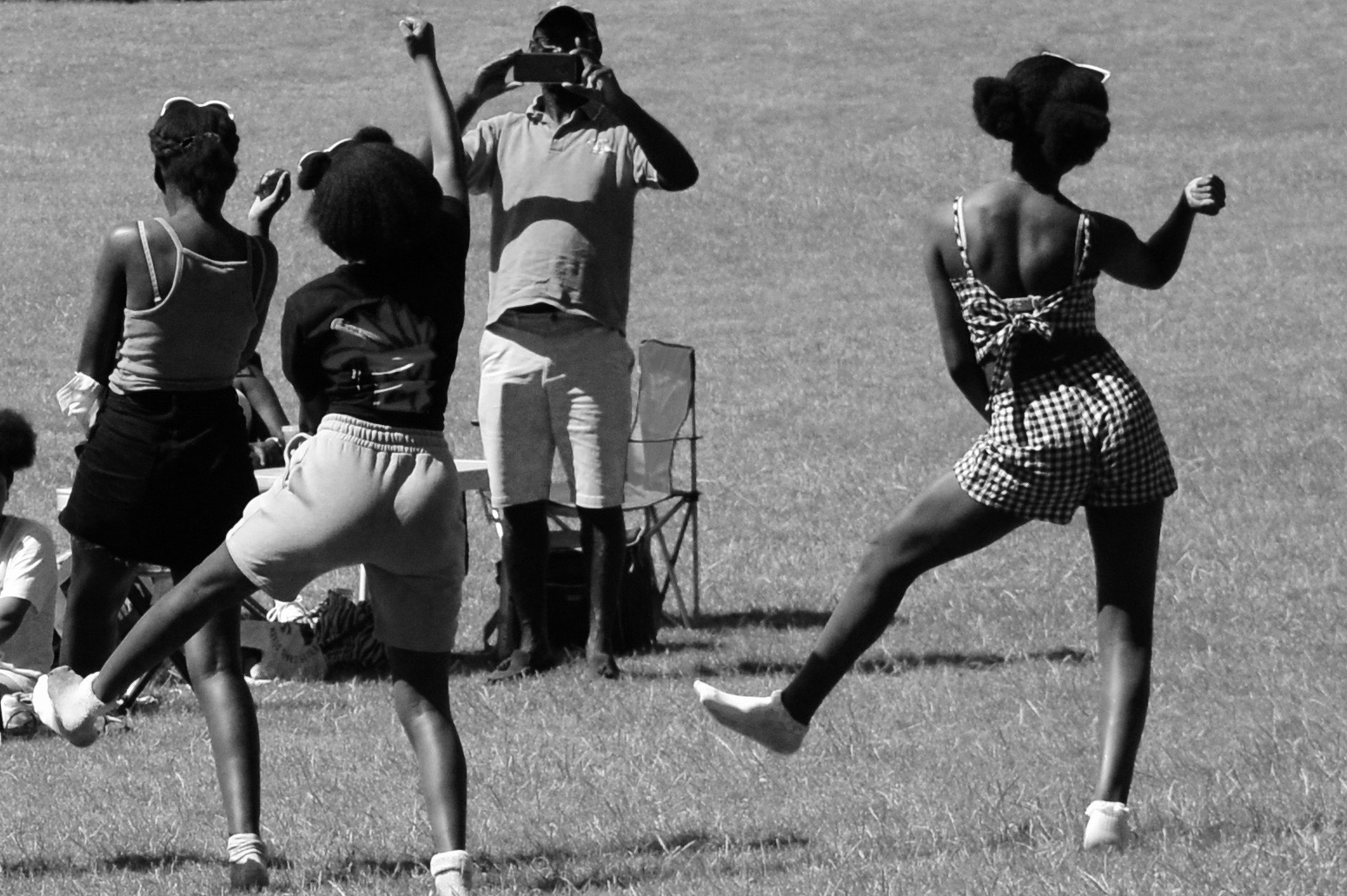 Young girls dancing in the park with their backs to the camera