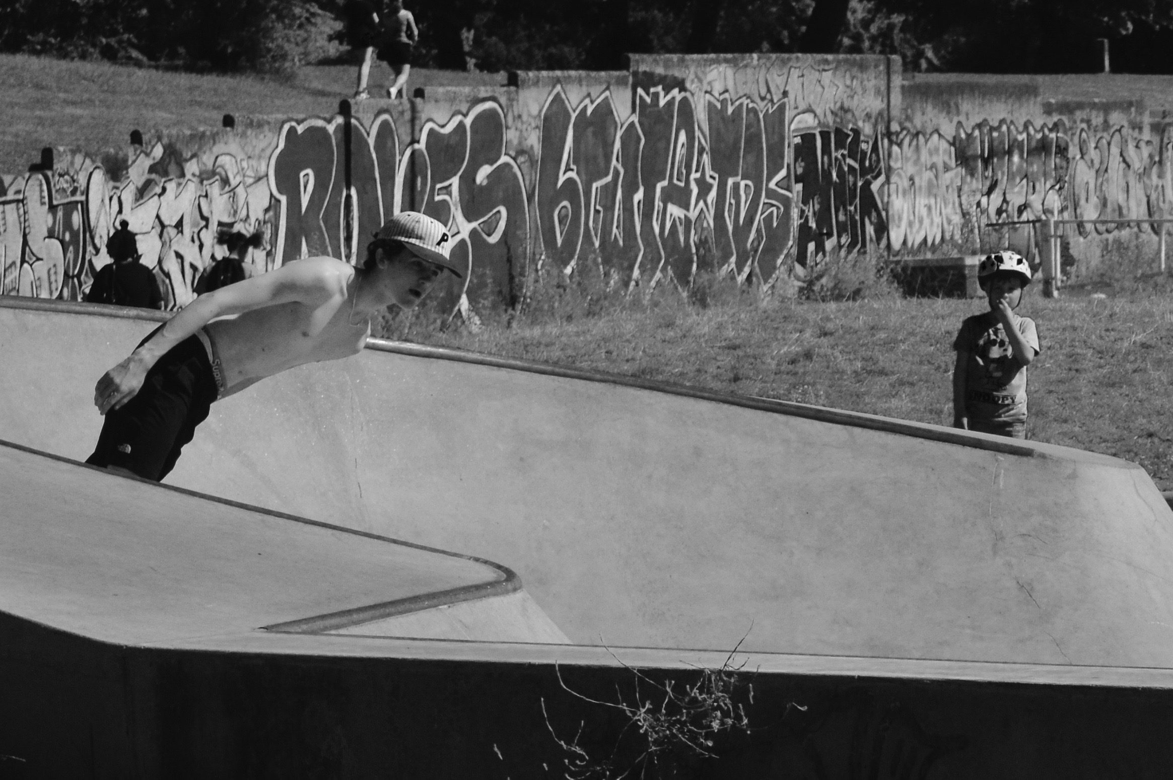 boy skating boarding while a younger boy watches on