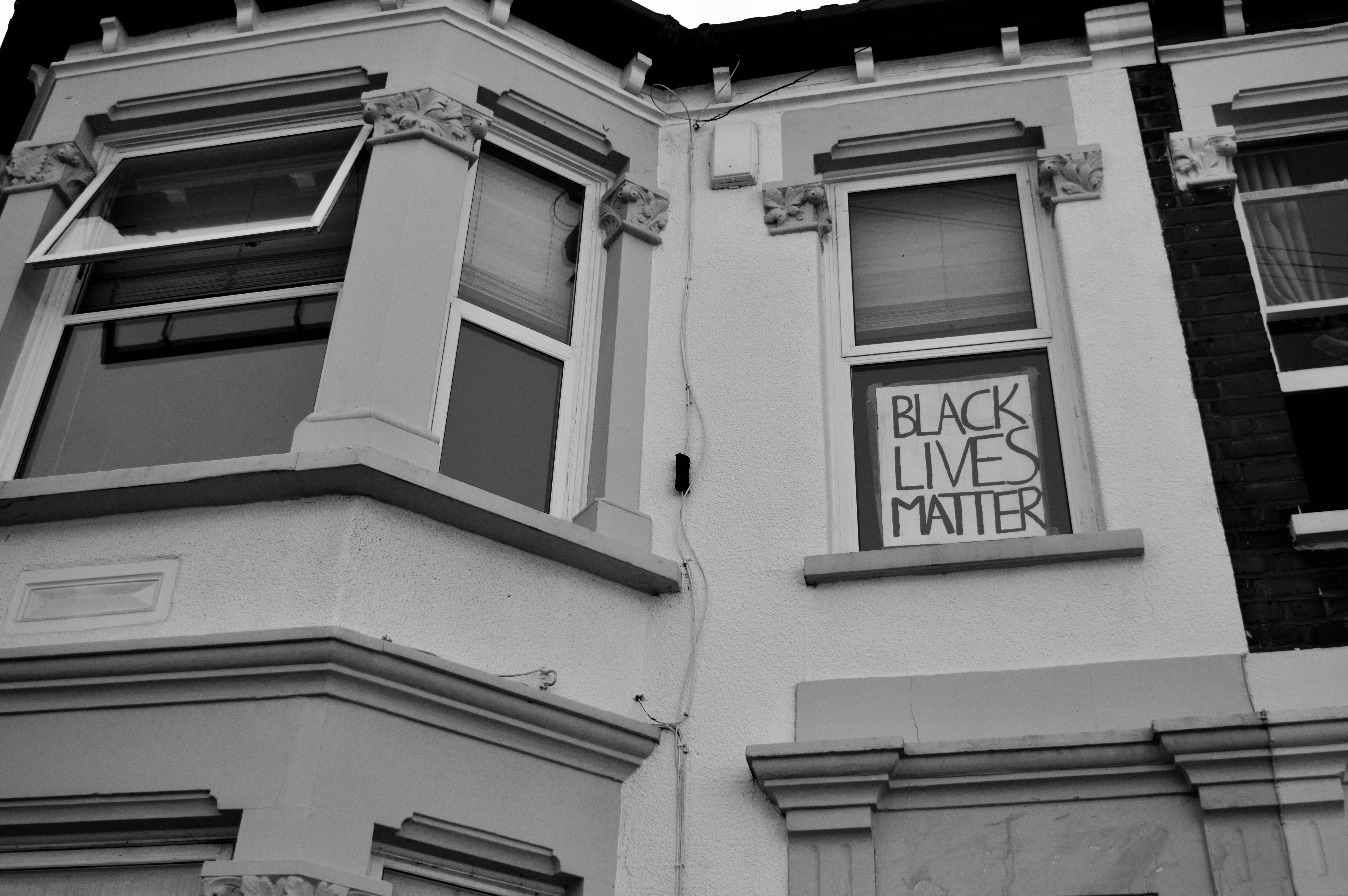 handmade black lives matter poster in the upstairs window of a house
