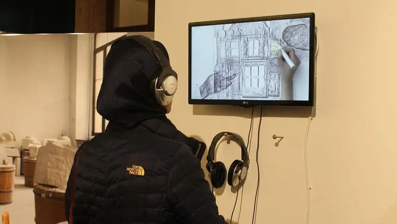 Visitor watching Becky Brewis' video 'Drawing From Memory'