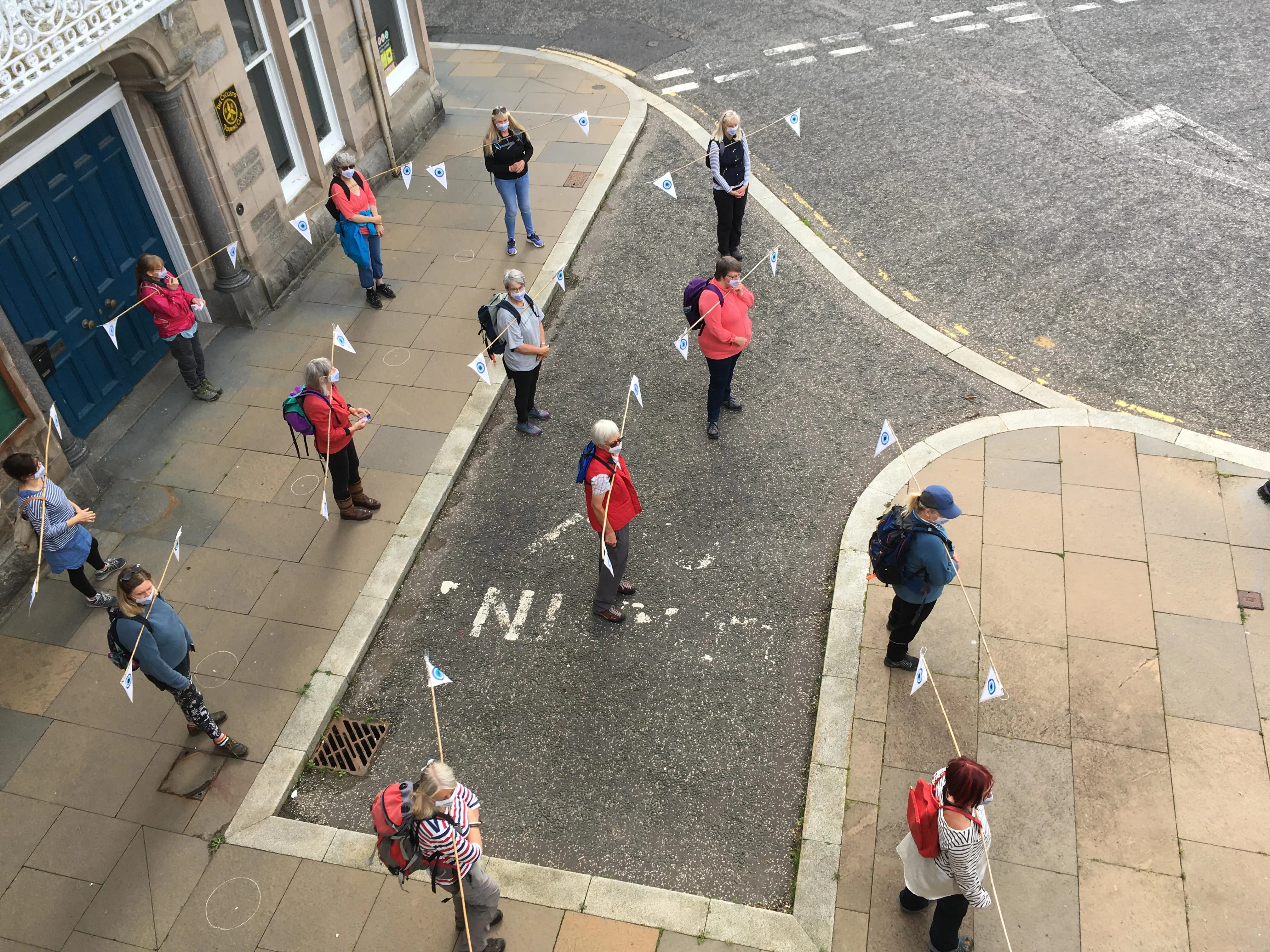 Persons standing socially distanced on a junction