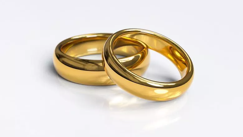 Two Gold Wedding Rings against a white background