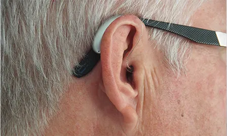 Close-up of a person's ear wearing a hearing aid