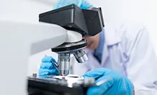 scientist looking into microscope