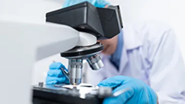 scientist looking into microscope