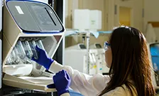 Woman introducing test tubes in machine