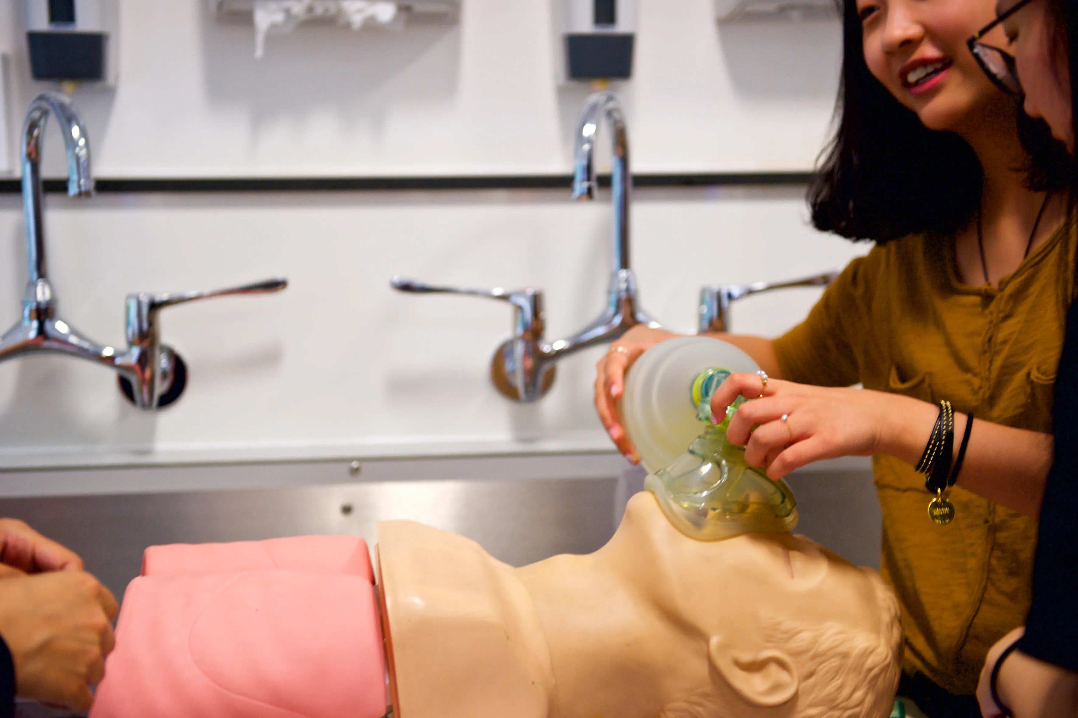 medical students practicing ventilation techniques on a training manikin