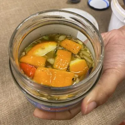 jar of fire cider includes oranges, lemon and garlic