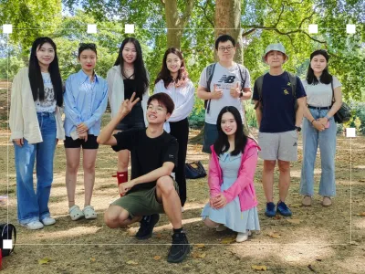 Jie with other members of the forum, a group of nine students, posing for a picture in a park.
