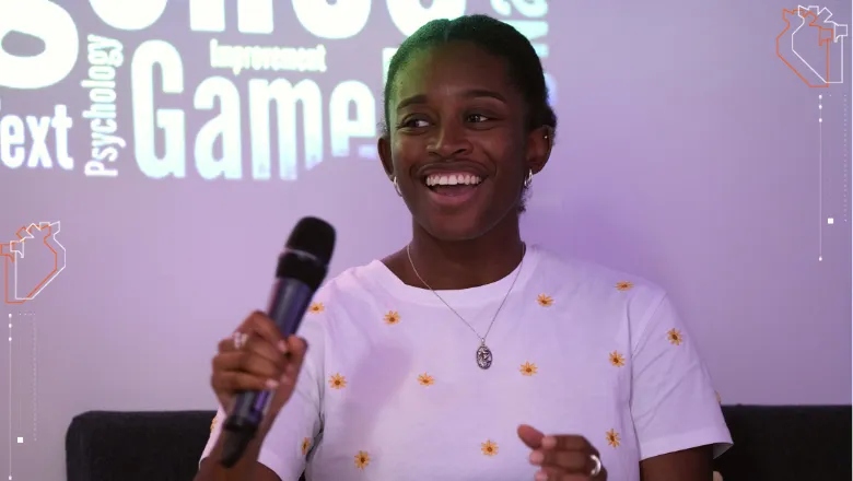 A picture of Tiarna Lee holding a mic to speak at an event.