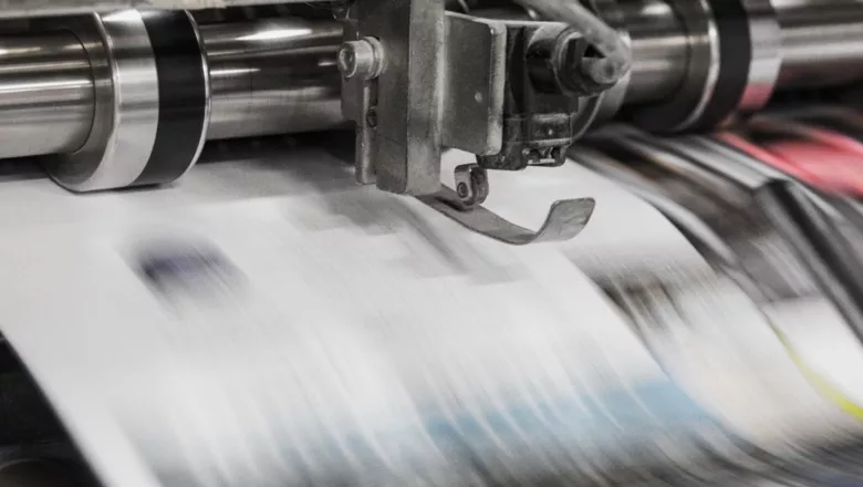 newspapers being made in a machine