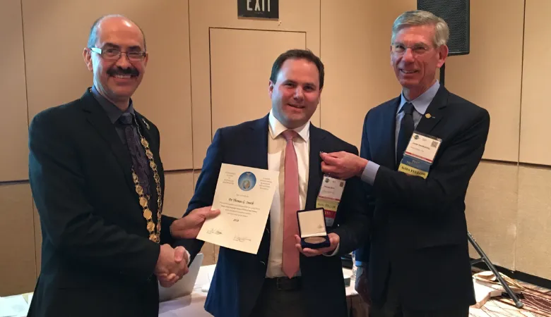 Thomas receiving membership medal and certificate as a newly elected Academician of the International Academy of Aviation and Space Medicine.