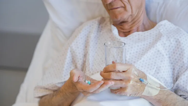 Elderly man taking medication in hospital