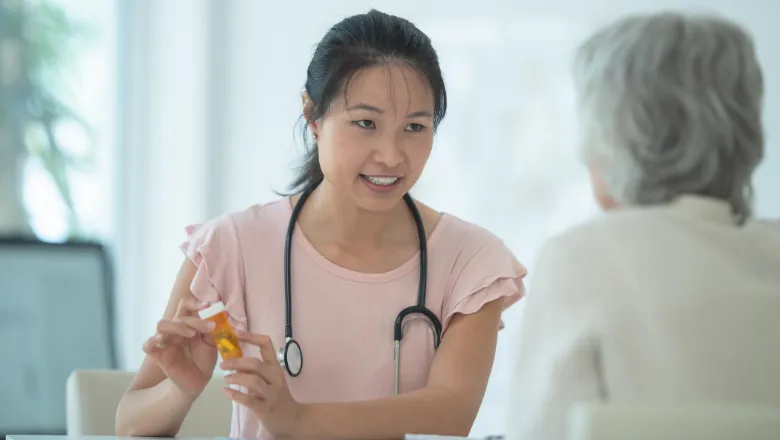 GP showing medication to eldely woman