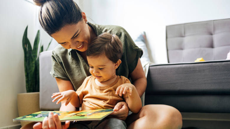 A woman and a child sit together, reading a book