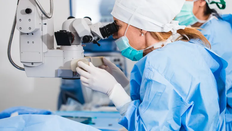 Ophthalmologists inspecting an eye through a microscope