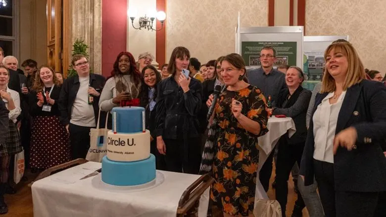 People gather around a blue and white cake