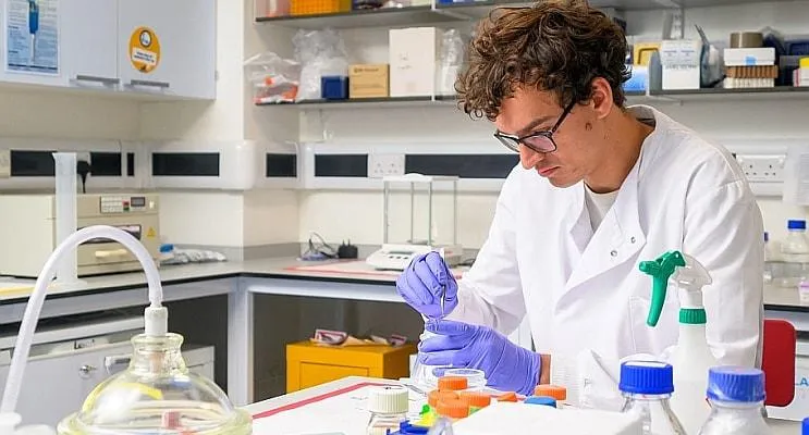 A man wearing a lab coat is conducting research