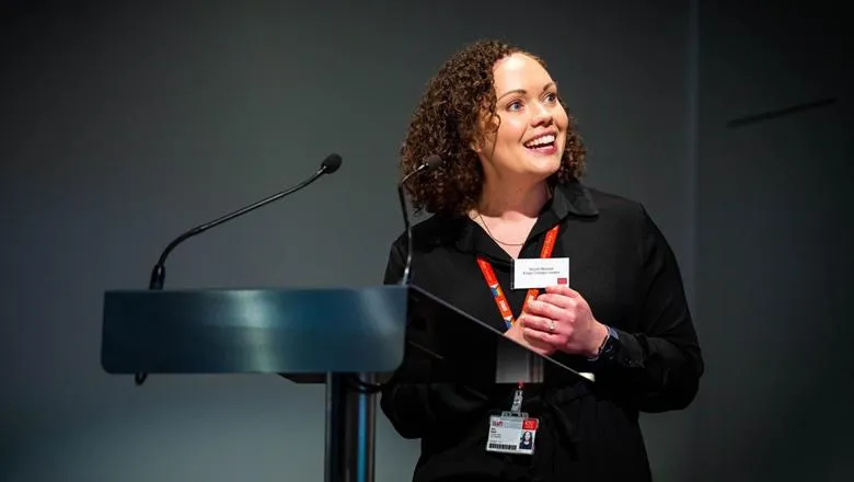Nicole Mennell standing at lectern 