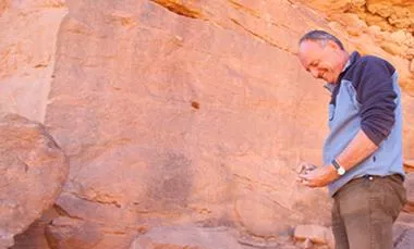 Professor Nick Drake examines a fossil finger bone.