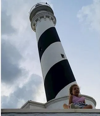 little girl sitting by lighthouse