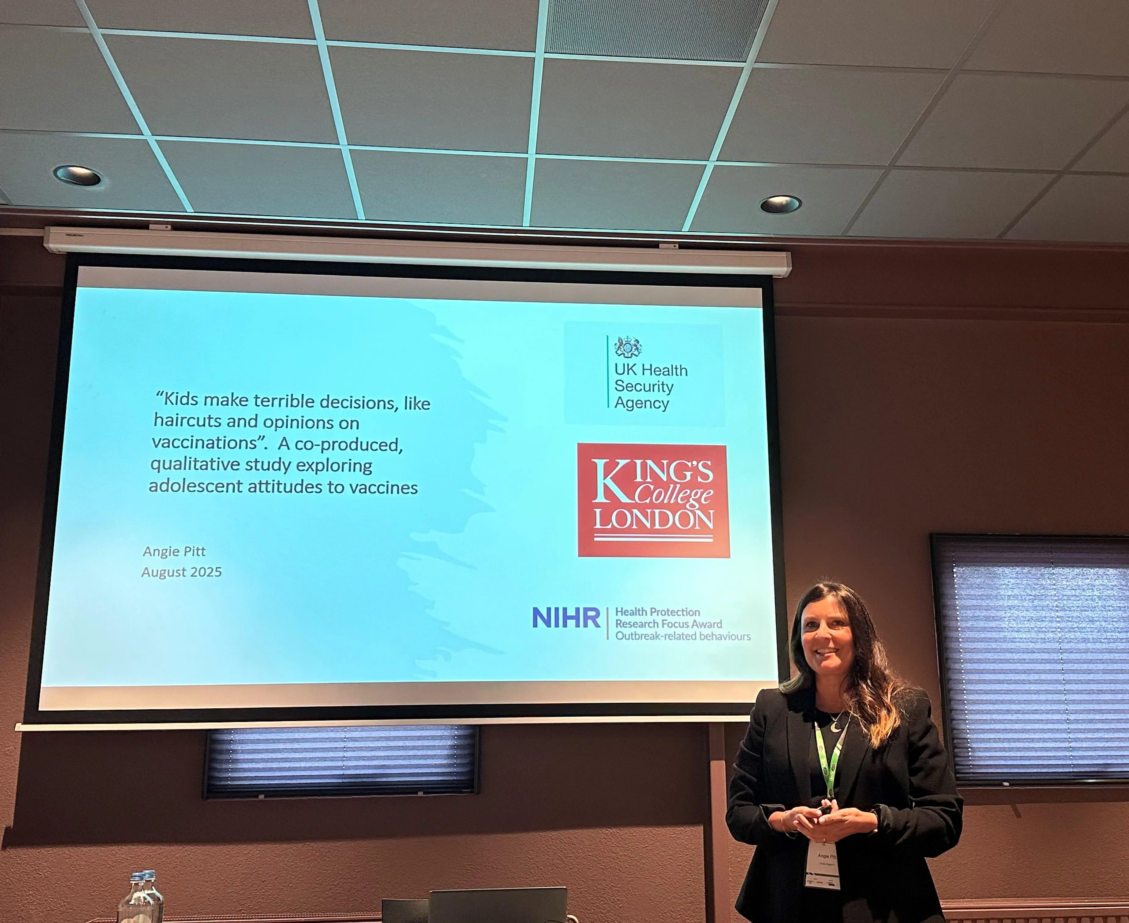 Angie standing beside a projected slide