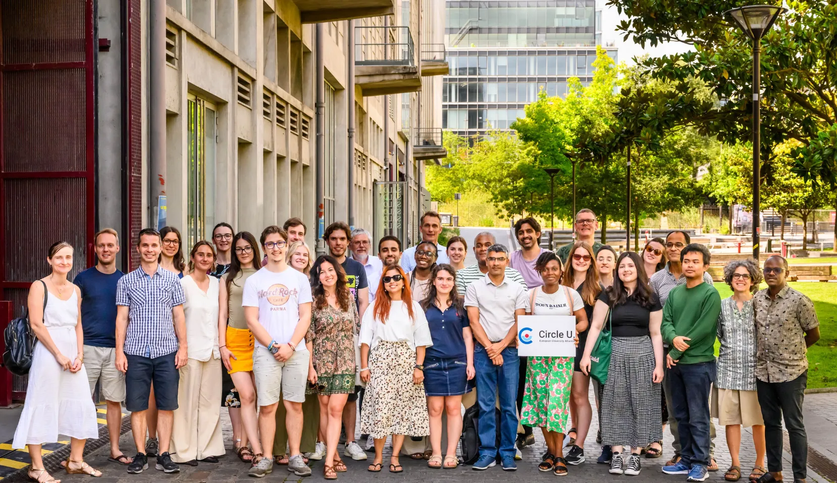 Group of 25 people smiling at the camera outdoors